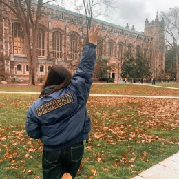a person in front of the university of Michigan in the fall