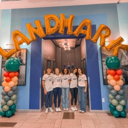people posing for a picture underneath balloons