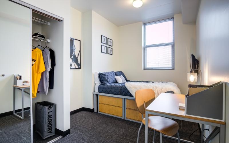 a bedroom with a bed desk and a chair