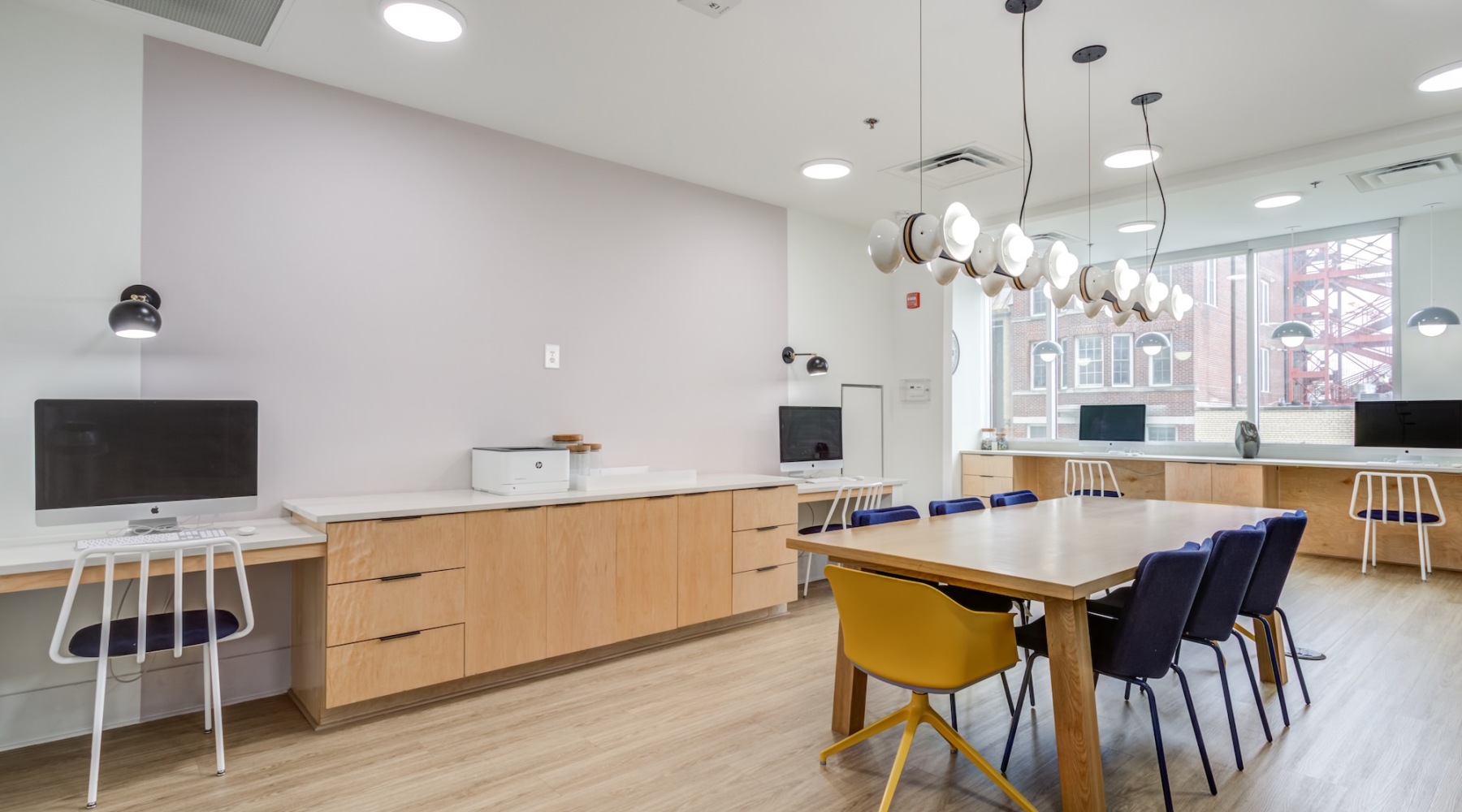 large lounge with seating and computers and windows